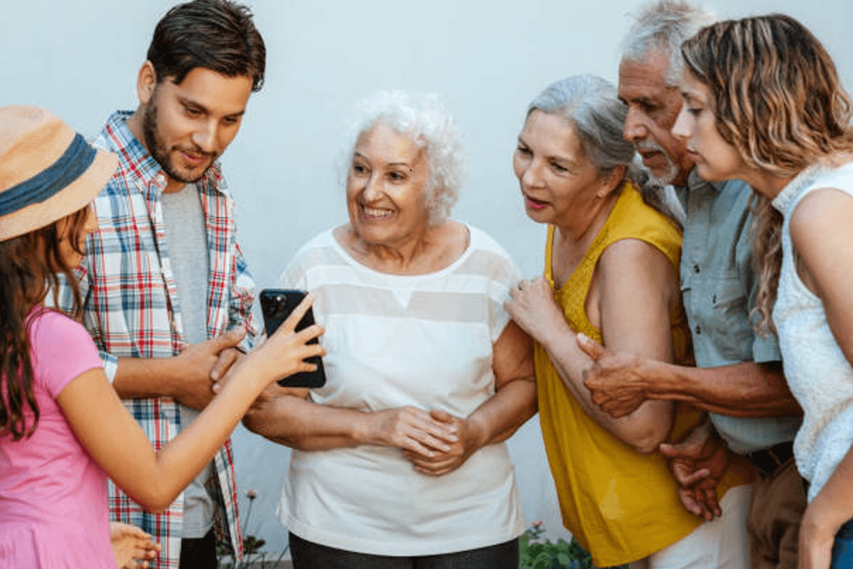 Gruppe von Menschen schaut gemeinsam auf ein Handy